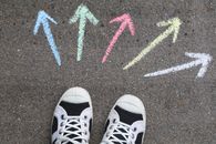 pexels-photo-2646530-2646530 Black sneakers on pavement with colorful chalk arrows pointing in different directions.